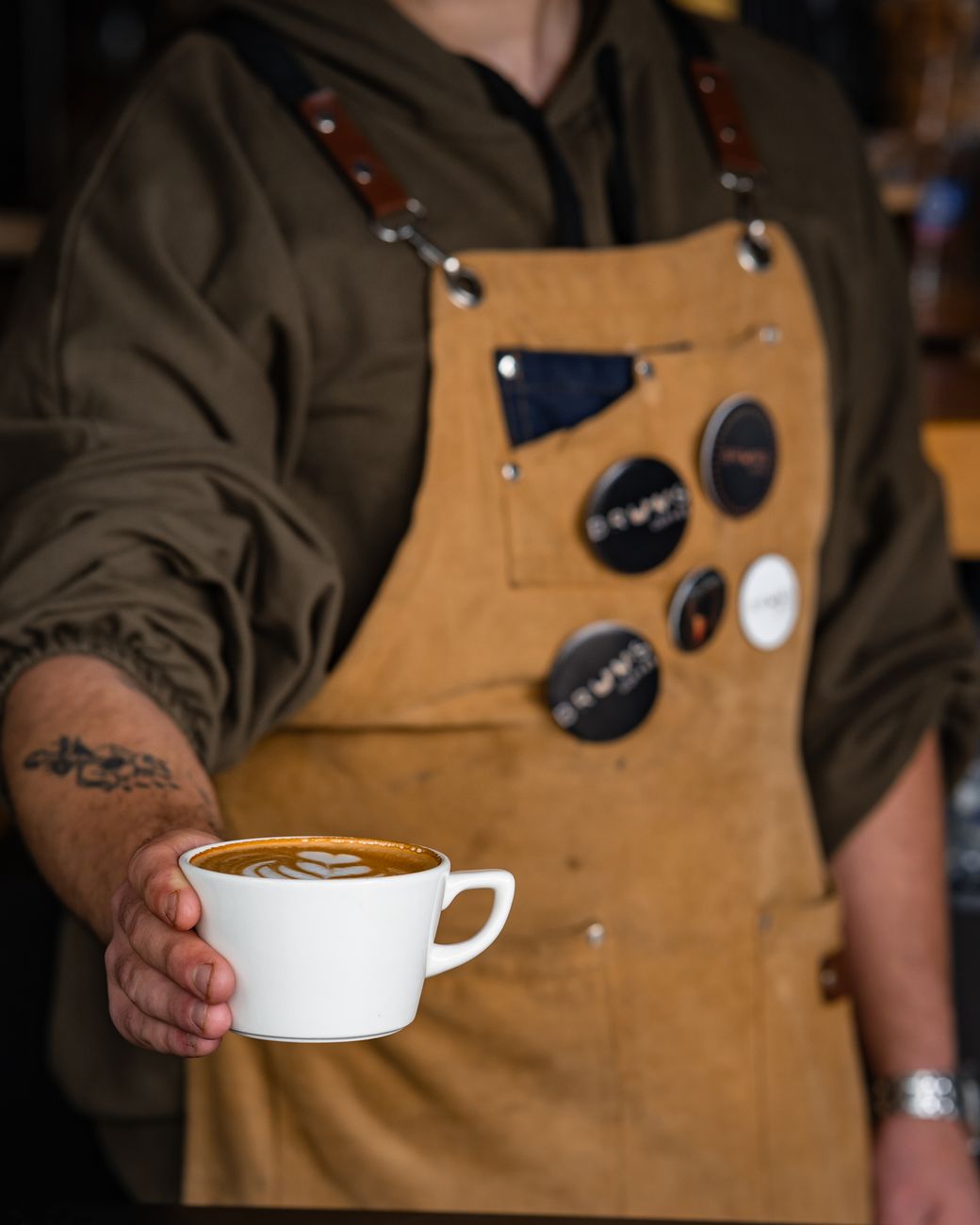 barista serving latte in artisan cafe