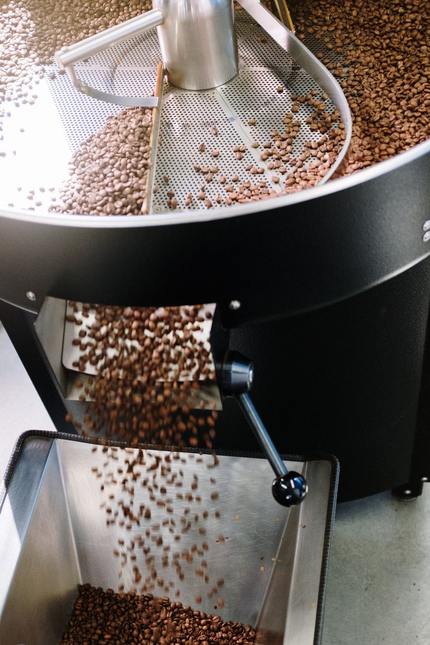 brown coffee beans on silver and black coffee maker